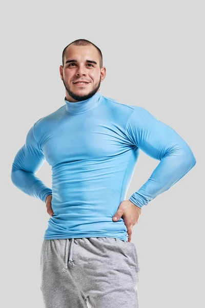 明るい灰色の背景に隔離された幸せな筋肉運動の男性のボディビルダーの肖像画 — ストック写真