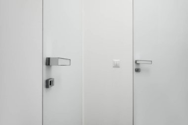 Modern odada ışık düğmesi olan beyaz kapıya yakın çekim