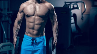 Halter tutan kaslı çıplak bir adamın portresi.