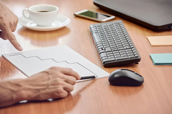 Side view of businessman drawing stairs on paper sheet