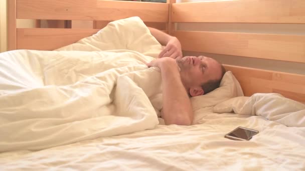 Yatakta Akıllı Telefon Kullanan Uyanık Uykucu Adam — Stok video