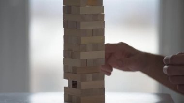 Ahşap bloklar kule oyunu oynayan adamın yakın plan fotoğrafı.