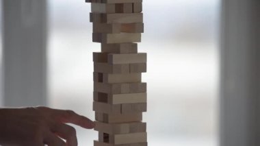 Ahşap kule oyunu oynayan kişinin yakınlaşması, piramidin düşmesi.