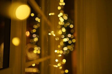 2021 yılının içinde mumlar, ampuller ve bokeh ile. Noel kutlaması için dekore edilmiş bir oda. Hediyeli Noel ağacı