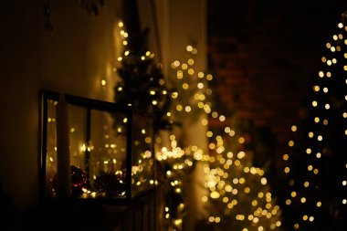 2021 yılının içinde mumlar, ampuller ve bokeh ile. Noel kutlaması için dekore edilmiş bir oda. Hediyeli Noel ağacı