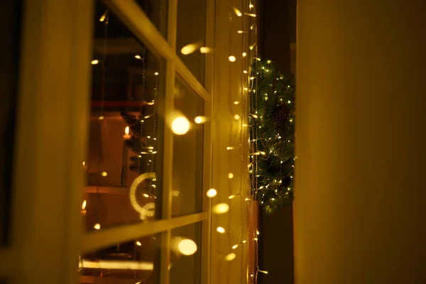 2021 yılının içinde mumlar, ampuller ve bokeh ile. Noel kutlaması için dekore edilmiş bir oda. Hediyeli Noel ağacı