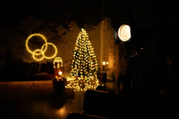 2021 yılının içinde mumlar, ampuller ve bokeh ile. Noel kutlaması için dekore edilmiş bir oda. Hediyeli Noel ağacı