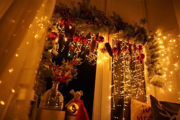 2021 yılının içinde mumlar, ampuller ve bokeh ile. Noel kutlaması için dekore edilmiş bir oda. Hediyeli Noel ağacı