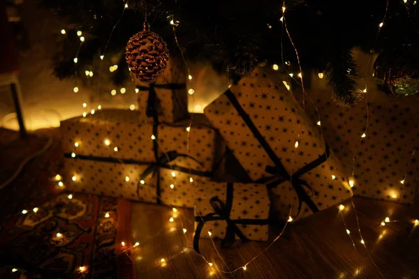 2021 yılının içinde mumlar, ampuller ve bokeh ile. Noel kutlaması için dekore edilmiş bir oda. Hediyeli Noel ağacı