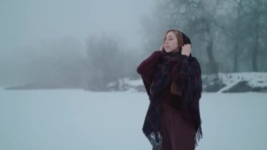 Buz gölündeki kar manzarasının tadını çıkaran bir kız.