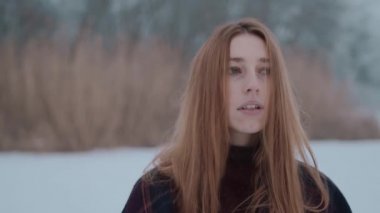 Buz gölündeki kar manzarasının tadını çıkaran bir kız.