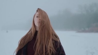 Buz gölündeki kar manzarasının tadını çıkaran bir kız.