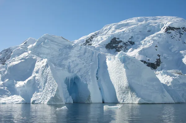 Айсберг с пещерой и горой позади него, Антарктика — стоковое фото
