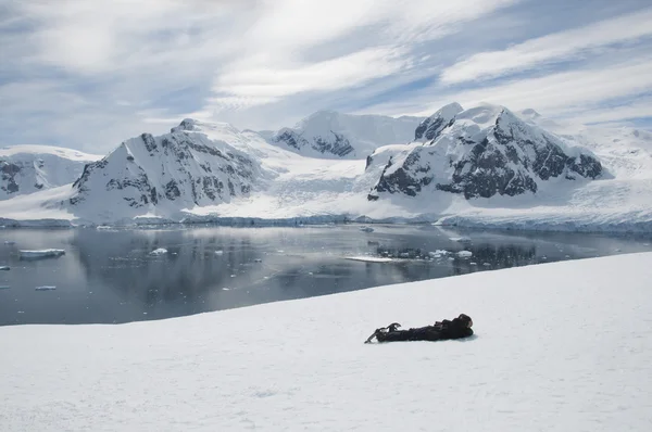 Hombre acostado en la nieve en la Antártida Fotos de stock libres de derechos