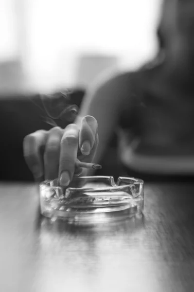 Main de femme avec une cigarette et un cendrier — Photo