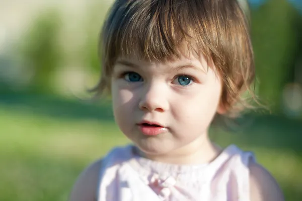 A little girl in a summer park — Stock Photo, Image