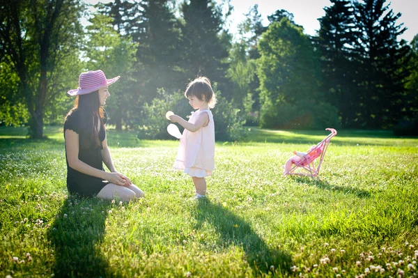 A little girl with mom in a summer park — Stock Photo, Image