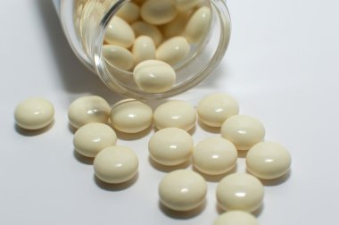 Beyaz arka plan üzerinde renkli sarı haplar