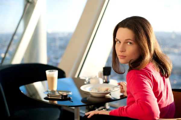The girl has breakfast in the café