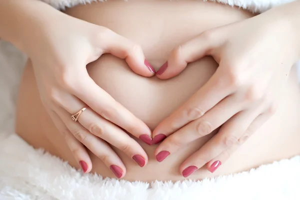 Terhes lány átölelve kezek has — Stock Fotó