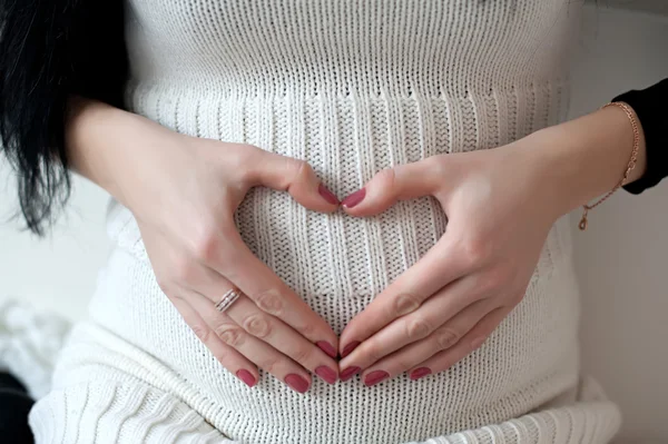 Menina grávida abraçando as mãos barriga — Fotografia de Stock