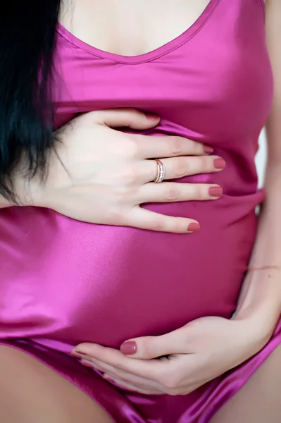 Pregnant girl hugging hands tummy Stock Image