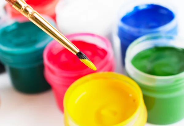 Brush and many paint jars with colored gouache