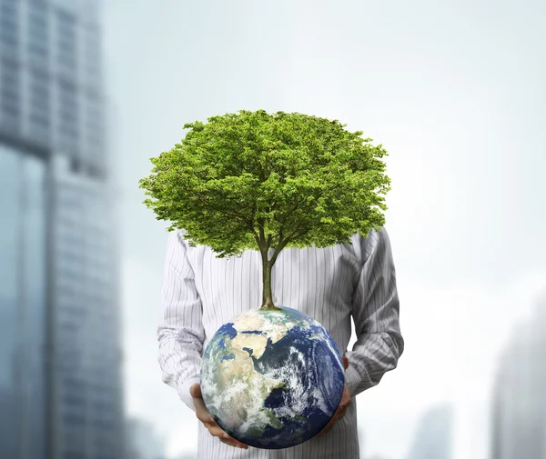 Holding a glowing earth (NASA) globe and tree in his hand — Stock Photo, Image