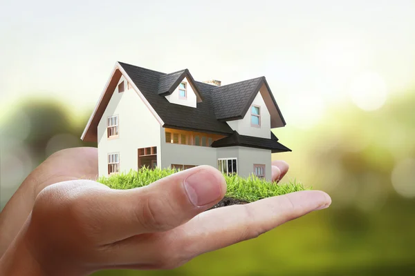 Huis in menselijke handen — Stockfoto