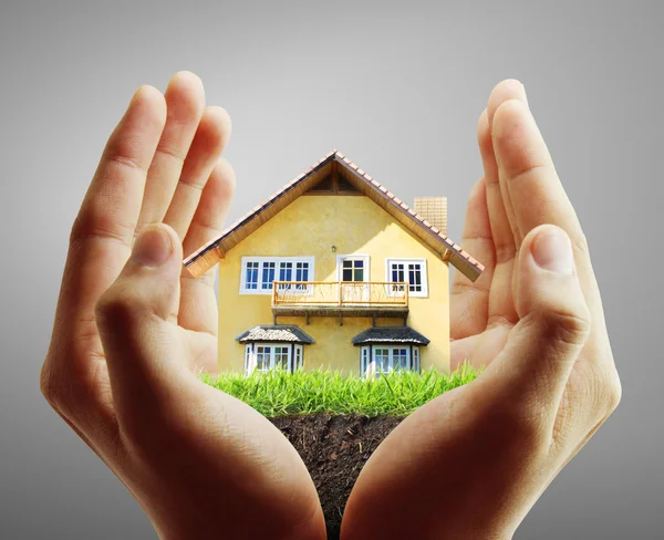 Huis in menselijke handen — Stockfoto