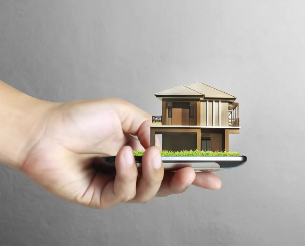 Casa en un teléfono móvil, en la mano —  Fotos de Stock