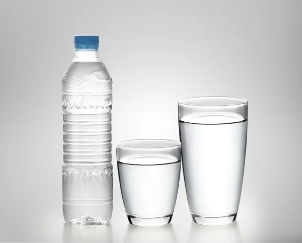 Бутылка воды со стеклом — стоковое фото