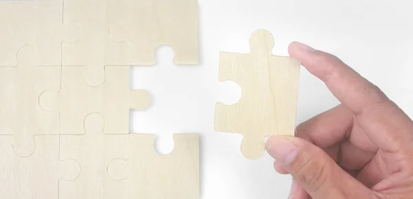 Connecting jigsaw puzzle in a hand. Business solutions success and strategy concept