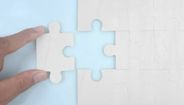 Connecting jigsaw puzzle in a hand. Business solutions success and strategy concept