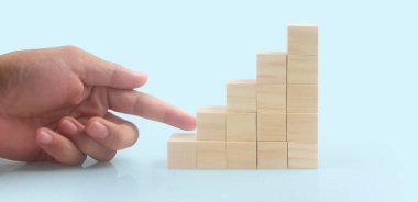 Business connecting piece of multi wood chart blocks steps in a hand