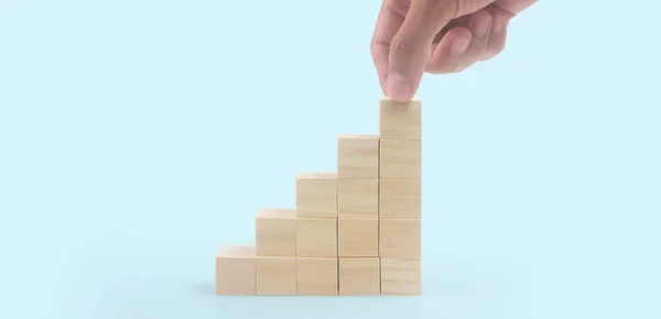 Business connecting piece of multi wood chart blocks steps in a hand