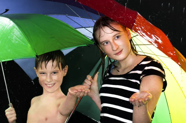 Crianças felizes andando sob a chuva — Fotografia de Stock