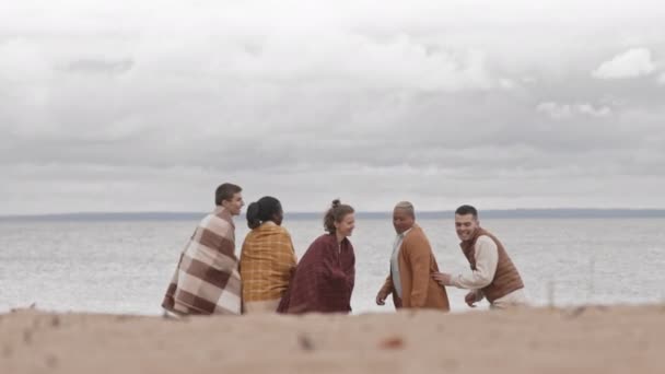 Κλειδωμένοι Πέντε Νέοι Άνθρωποι Που Στέκονται Στην Ακτή Αγκαλιασμένοι Ζεσταμένοι — Αρχείο Βίντεο