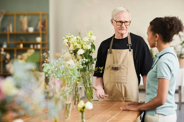 Senior Man pratar med kunden i butiken — Stockfoto