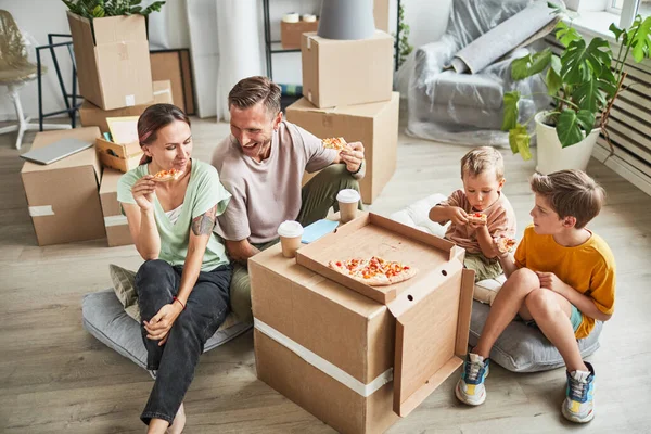 Rodina jíst pizzu v novém domově — Stock fotografie
