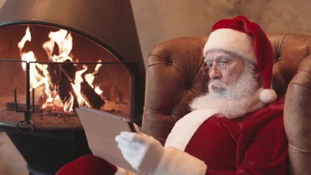 Noel Baba Nın Kırmızı Beyaz Şapkalı Gözlüklü Hali Şöminenin Yanındaki — Stok video