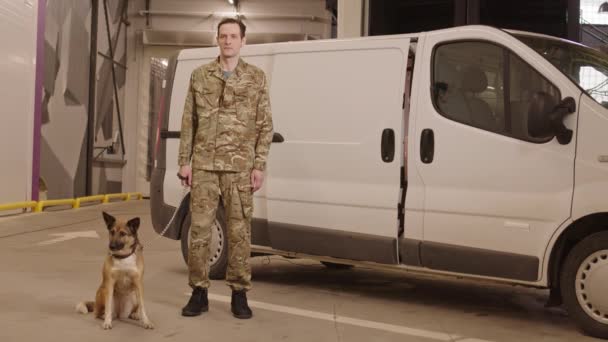 Szerokie Ujęcie Mężczyzny Kaukaskiego Specjalisty Bezpieczeństwa Trzymającego Psa Smyczy Stojącego — Wideo stockowe