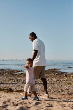 Baba ve oğul sahilde yürüyor.