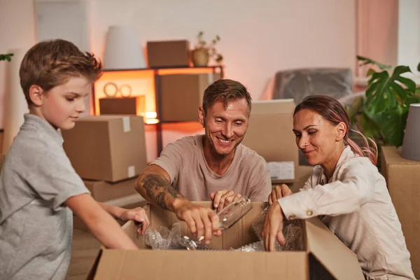 Familia moderna desempacando en un nuevo hogar — Foto de Stock