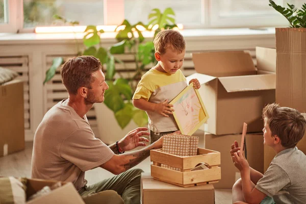 Father and Sons Unpacking Box — Stock Photo, Image