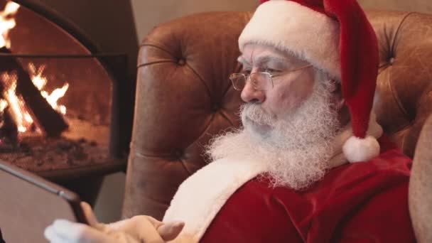 Pecho Santa Claus Con Sombrero Anteojos Sentados Sillón Junto Chimenea — Vídeo de stock