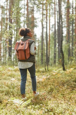 Sırt çantalı genç kadın dışarıda yürüyüş yapıyor.