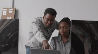 Ofiste yeni program ya da yazılım geliştirirken genç Afro-Amerikan programcıların belden yukarısından çekimleri.