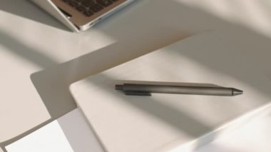 Bilgisayarlı, akıllı telefonlu ve defterli hiç kimse modern minimalist ofisteki güneş ışığında beyaz masaya bakamaz.