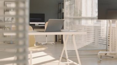 Kimse modern çalışma masaları, dizüstü bilgisayarlar ve bilgisayar monitörleri, güneş ışığı, bölme duvarları olan çağdaş siyah beyaz ofis iç tasarımı çekmiyor.